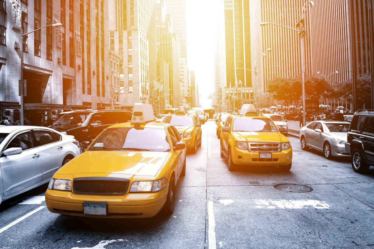 A fleet of taxis driving down a street