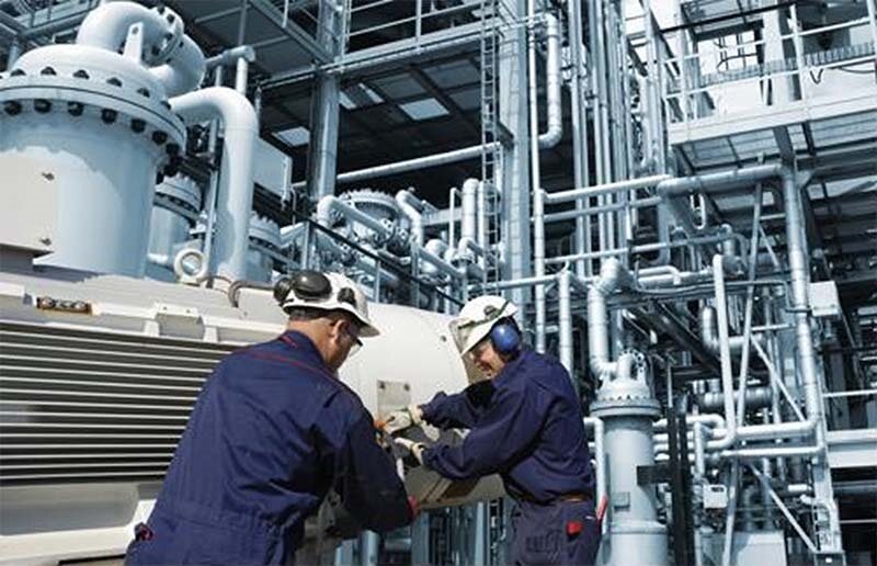 Workers at an energy facility where industrial cellular routers can be used.