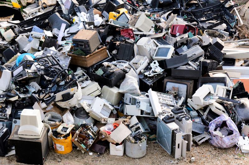 A pile of  old and broken electronics at a dump.