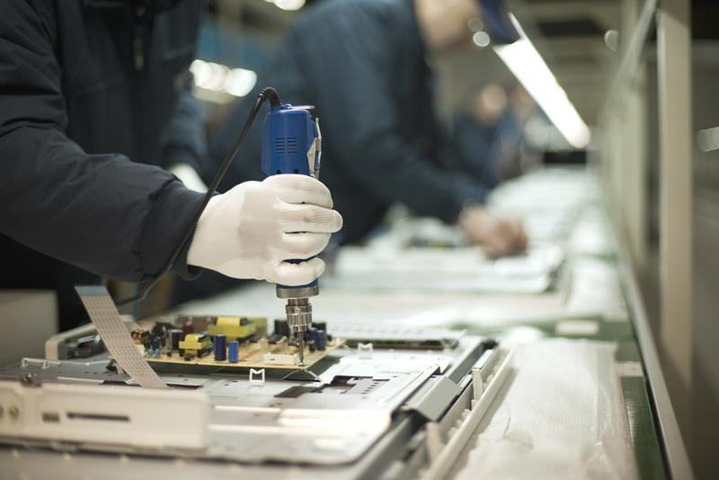 Manufacturing workers put together electronics products