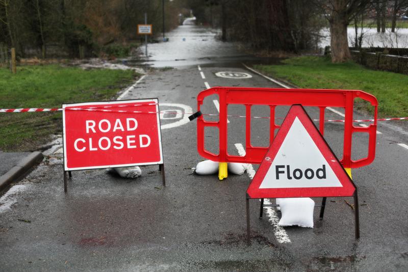 Road sign blocking flooded street.