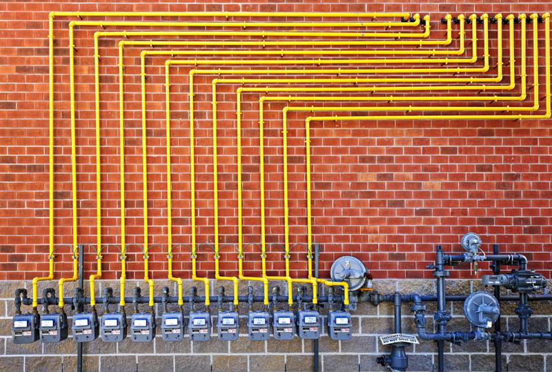 Natural gas lines installed on the outside of a brick building