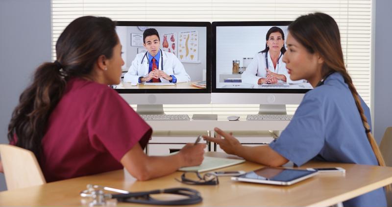 Nurses and doctors discuss a patient over video conferencing. 