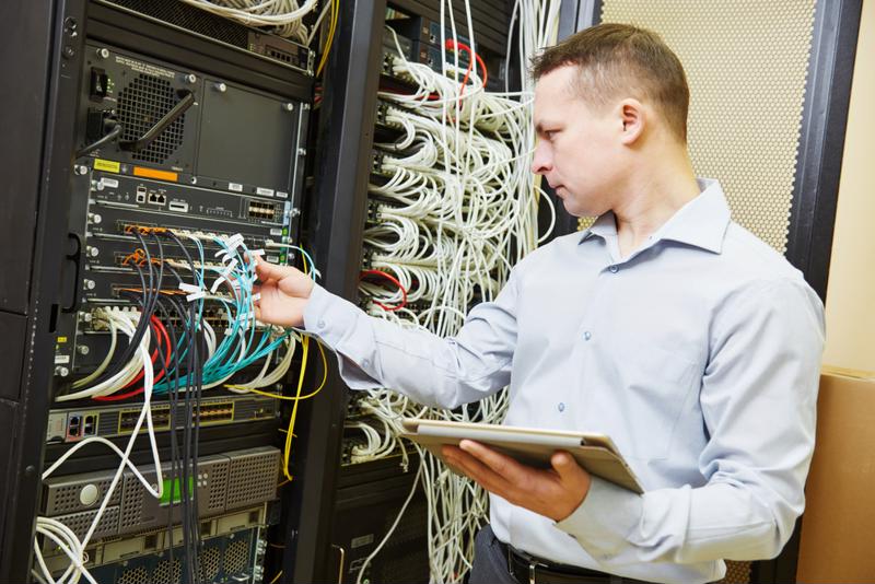 Data center worker checking network cables.